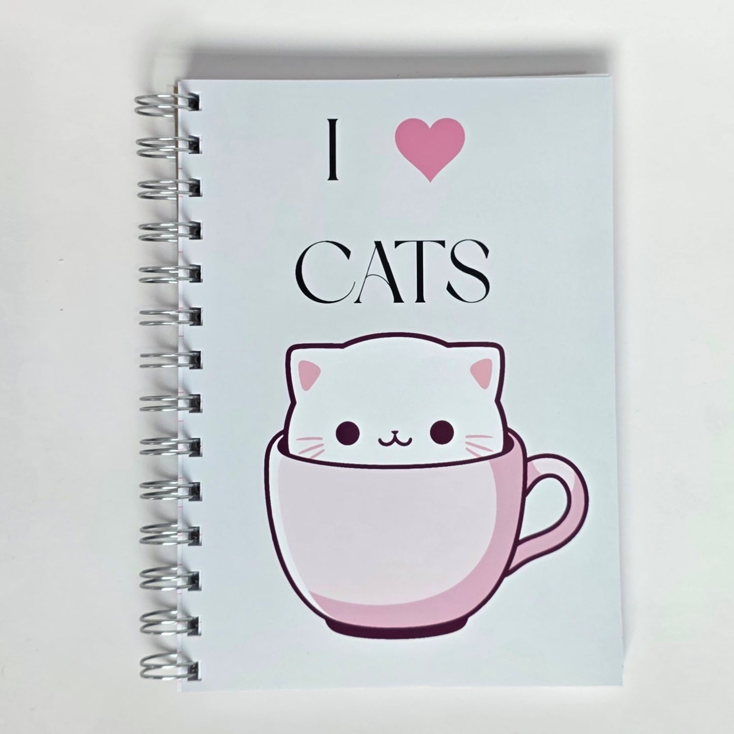 Cute cat notebook with “I Love Cats” text and white cartoon cat in pink teacup on glossy cover