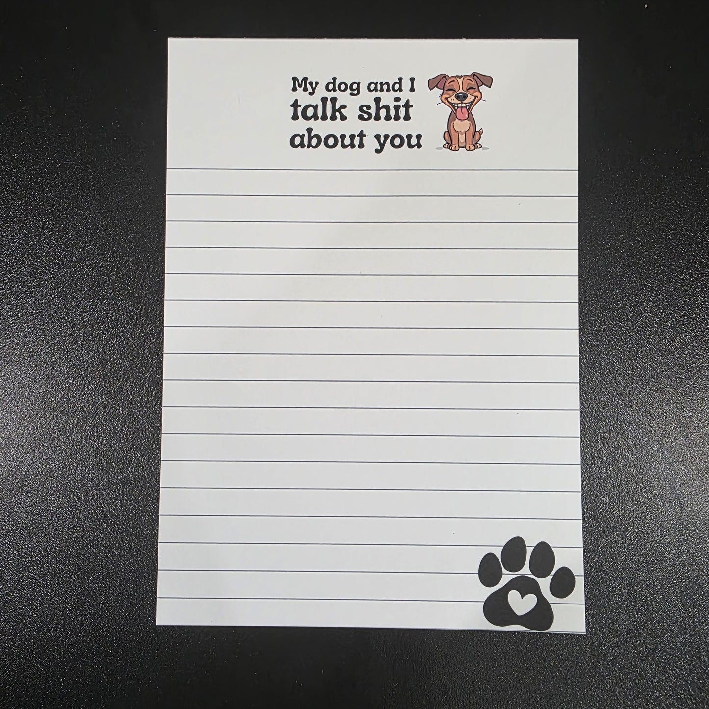Notepad with lined pages and humorous text on a black background