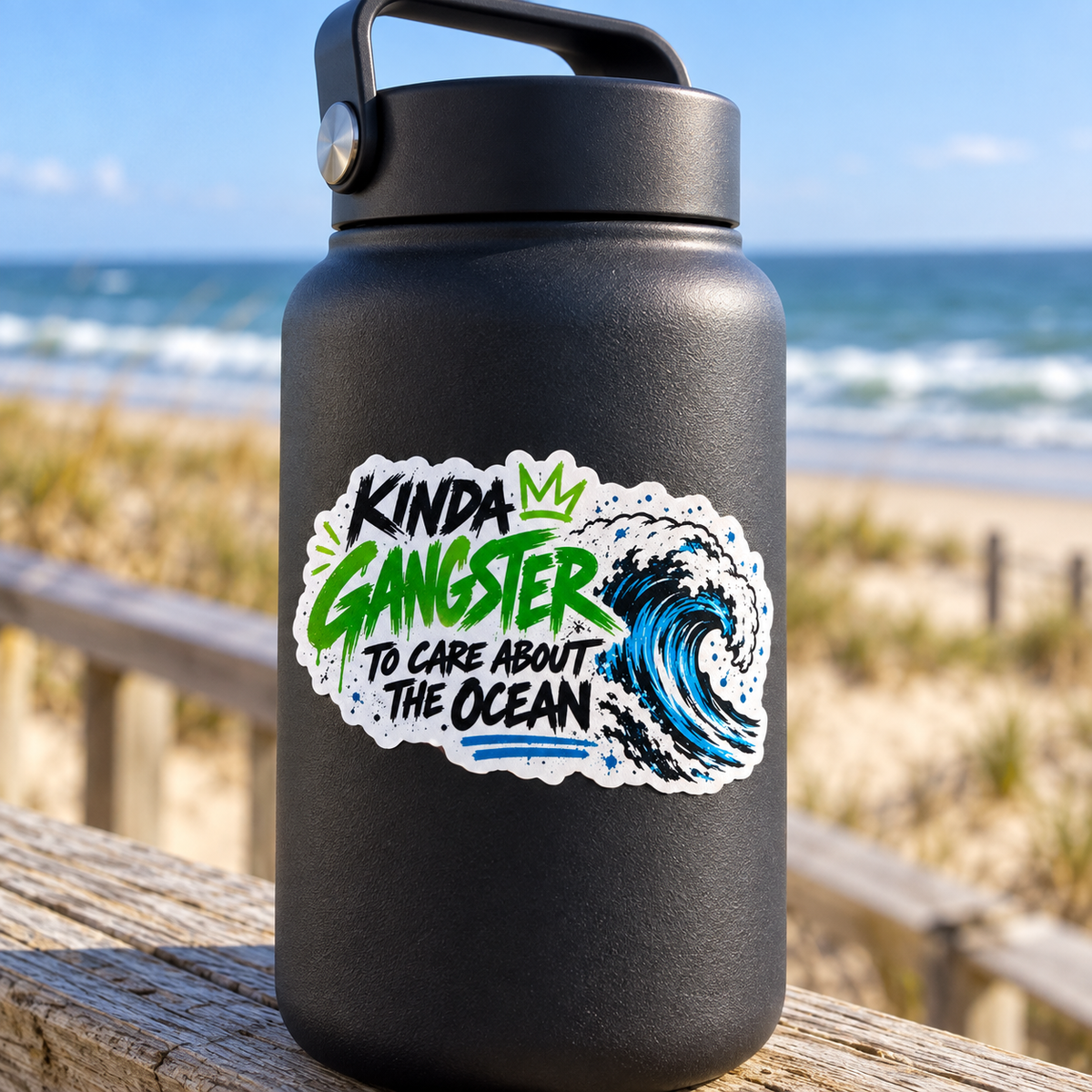 Kinda Gangster to Care About the Ocean sticker on a dark reusable bottle by the shore.